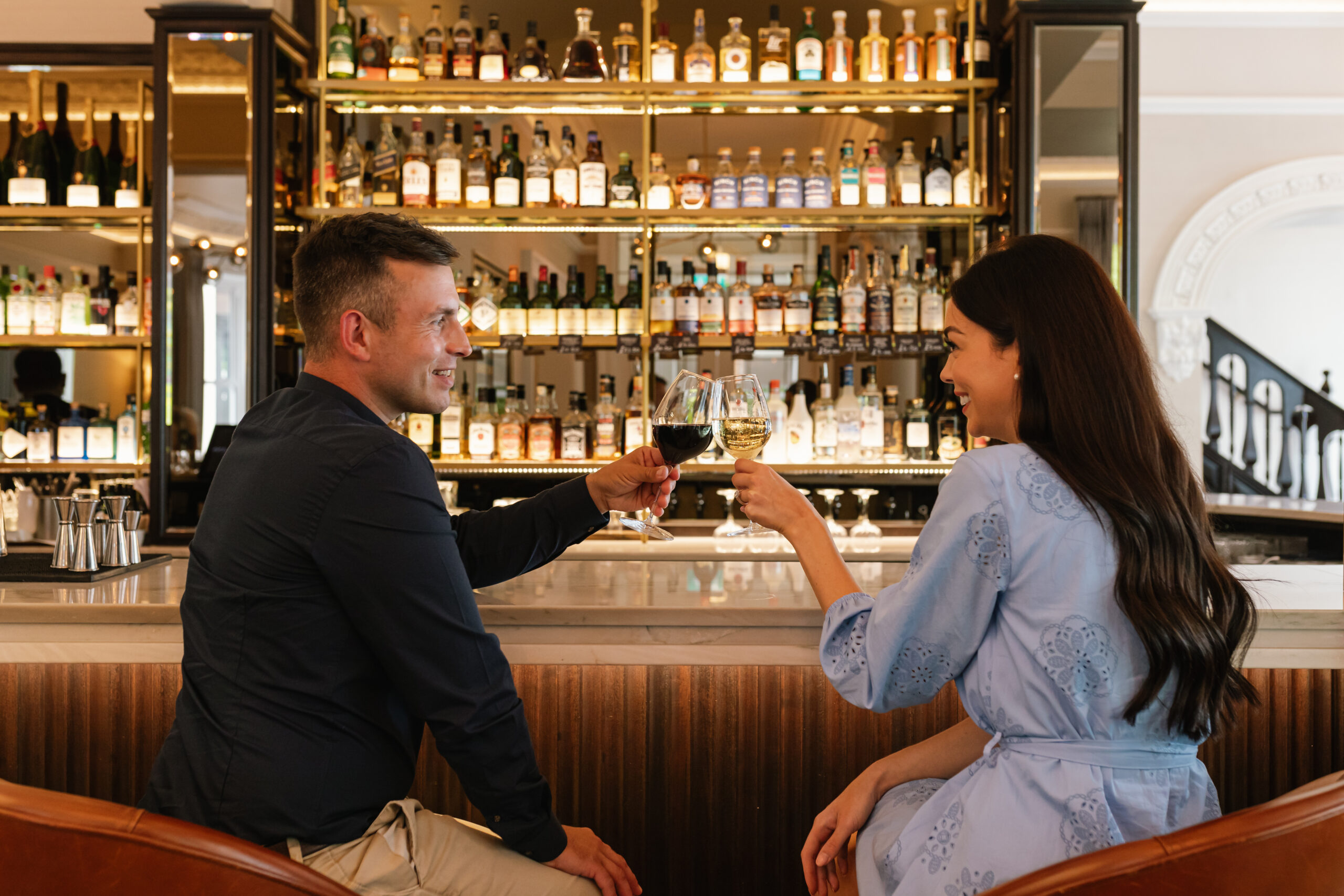 A happy couple at a bar having a glass of wine